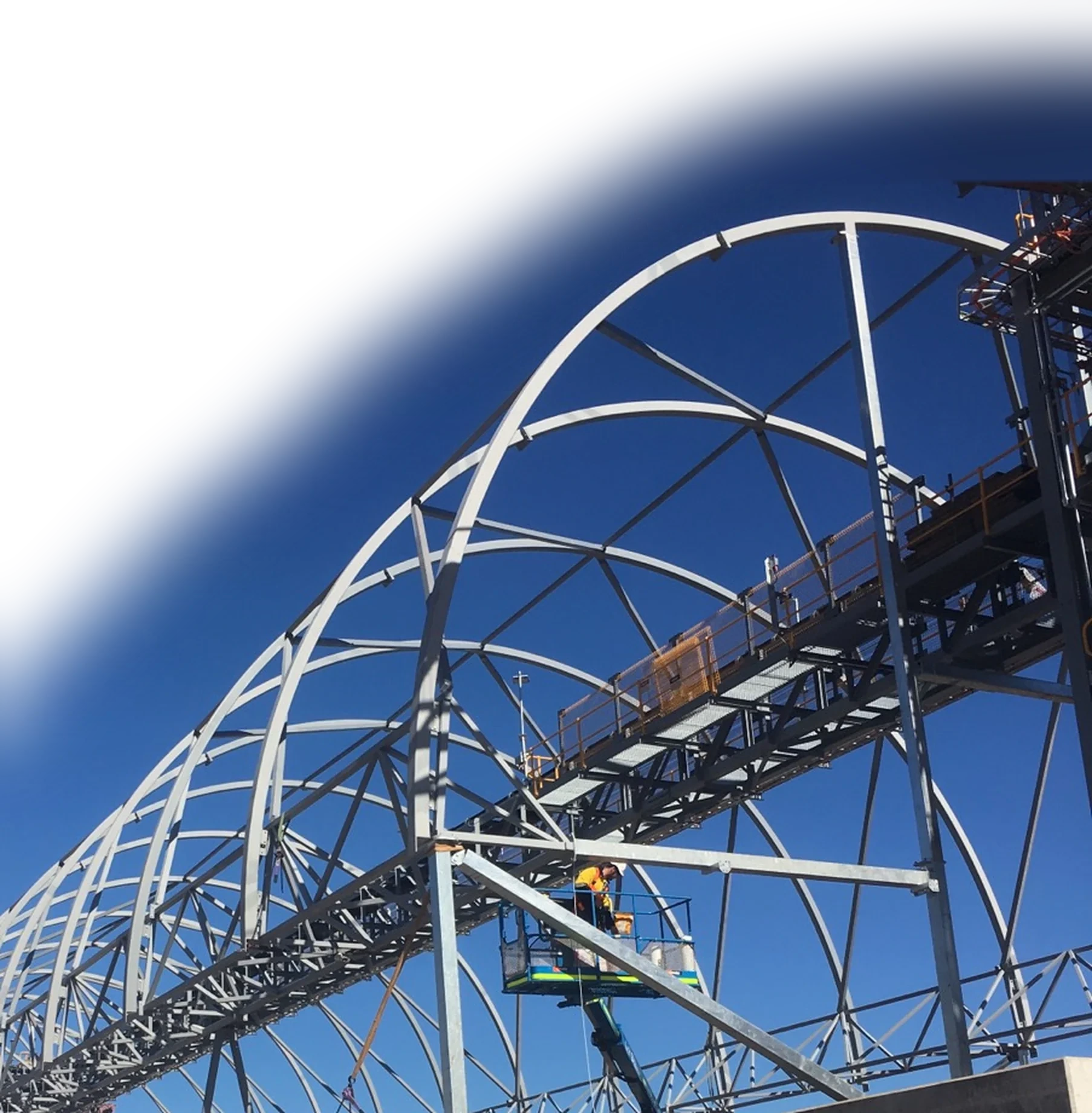 Arched steel structure erected on site against a deep blue sky, detailed by GuruCADD